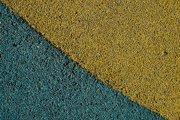 Grünlich blau und gelb lackierte winzige Steine. Hintergrund aus Kies. - Foto, Bild