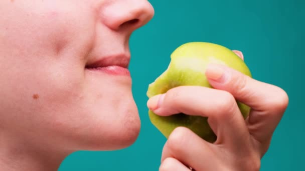 Alimentación saludable y dientes o dieta saludables, mujer joven muerde una manzana fresca en un primer plano de pantalla verde
 - Metraje, vídeo