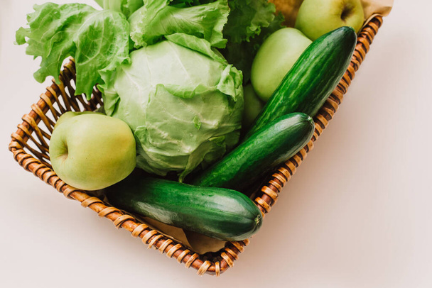 Зеленые овощи и фрукты в корзине. Огурцы, капуста, салат, яблоки и травяные изолированные на белом фоне. Детоксикация и зеленая диета. Понятие здорового образа жизни. Эко-жизнь
 - Фото, изображение