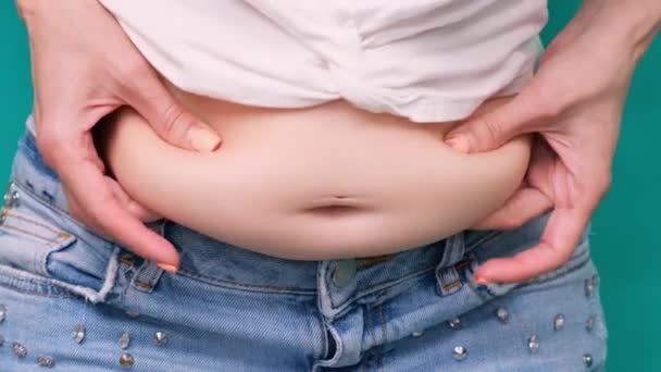 Товста жінка, жінка з ожирінням, тримає надмірний жир живота ізольований на зеленому фоні, товстий живіт жінки, концепцію способу життя жінки, щоб зменшити живіт і сформувати здоровий м'яз шлунка. - Кадри, відео