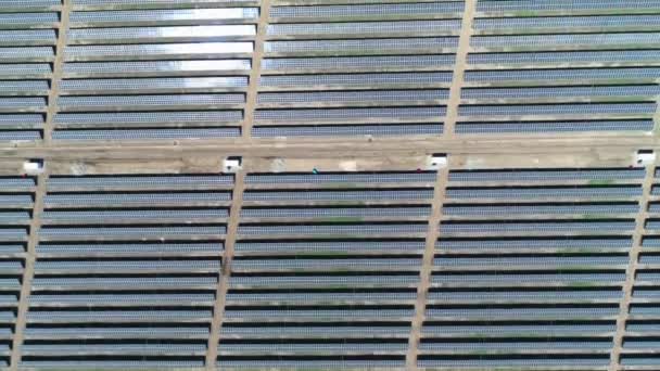 Antenni ylhäältä alas näkymä aurinkovoimalan kentän aurinkoisena päivänä. Antenni ylhäältä näkymä Solar Farm. Uusiutuvan energian teknologia. Laaja kuva
 - Materiaali, video