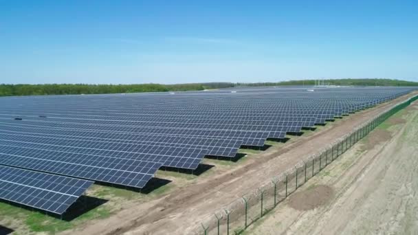 Vista aérea do campo da central solar no dia ensolarado. Vista aérea superior da fazenda solar. Tecnologia de energia renovável. Tiro largo
 - Filmagem, Vídeo