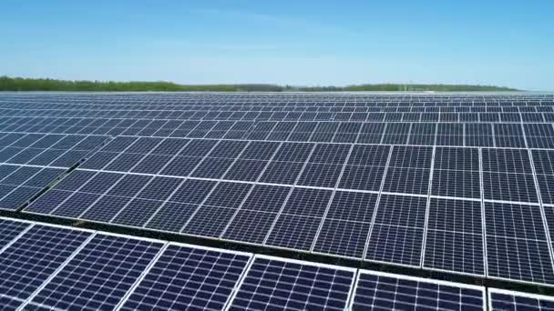 Güneşli bir günde güneş enerjisi santralinin hava görüntüsü. Güneş Çiftliği 'nin Havadan Görünümü. Yenilenebilir enerji teknolojisi. Geniş açı - Video, Çekim