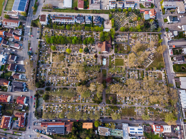 Вид сверху на городское кладбище в Верншафте. Ряды могил. Серые деревья. Германия
. - Фото, изображение