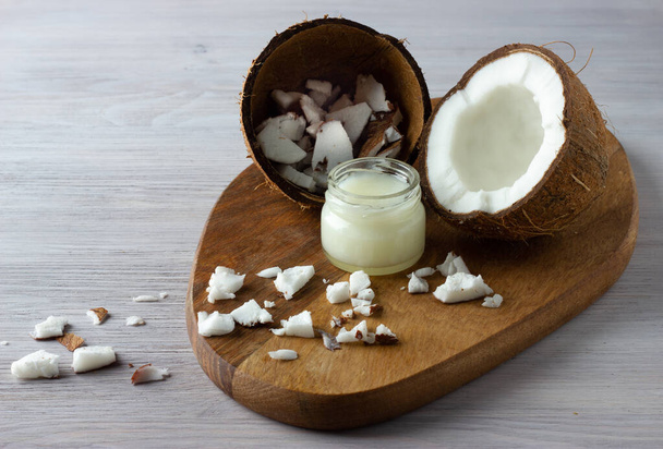 Coconut oil and fresh coconuts on the wooden table - 写真・画像
