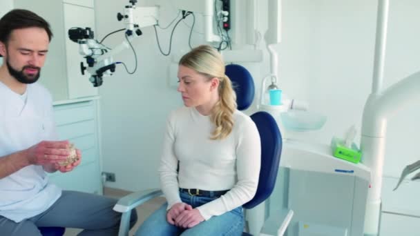 Dentist showing patient dental model - Footage, Video