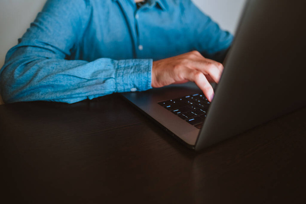 Close-up of a man working on a laptop. - Φωτογραφία, εικόνα