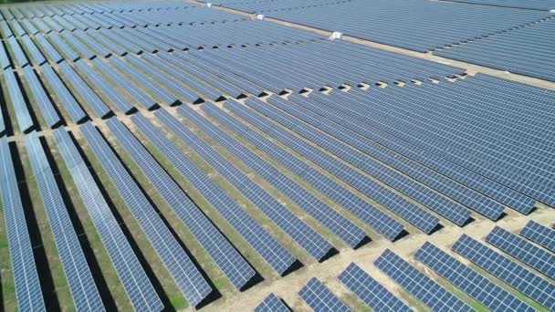 Güneşli bir günde güneş enerjisi santralinin hava görüntüsü. Güneş Çiftliği 'nin Havadan Görünümü. Yenilenebilir enerji teknolojisi. Geniş açı - Video, Çekim
