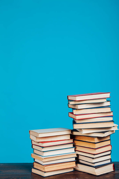 πολλά εκπαιδευτικά βιβλία για τις εξετάσεις κολέγιο σχετικά με το μπλε φόντο της βιβλιοθήκης - Φωτογραφία, εικόνα