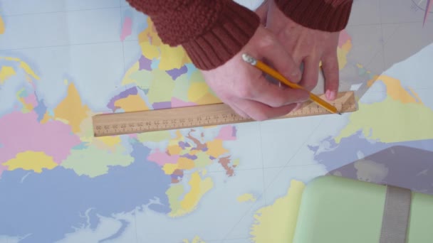 Un hombre dibuja una línea en un mapa y escribe en un cuaderno
 - Metraje, vídeo