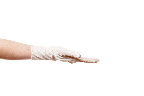 χέρι σε ένα αποστειρωμένο λευκό γάντι κρατά μια χειρονομία επίδειξης παλάμης που απομονώνεται σε λευκό φόντο με ένα χώρο αντίγραφο. - Φωτογραφία, εικόνα