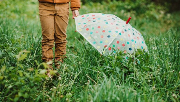 Feet of child in yellow rubber boots and colorful umbrella in the rain. - Fotoğraf, Görsel