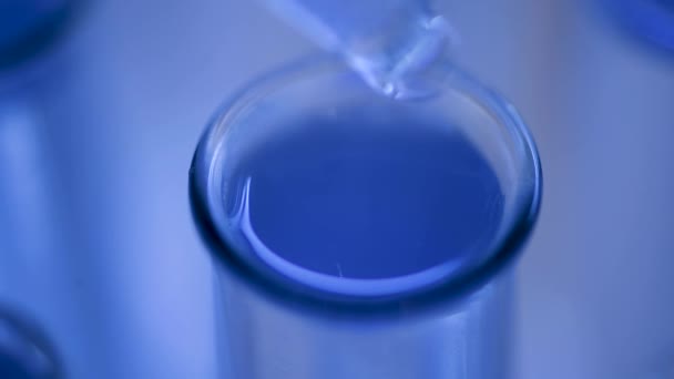 У лабораторії вчений з трубкою аналізує синю рідину, щоб отримати ДНК і молекули в пробірці. Доктор працює з рідиною.. - Кадри, відео