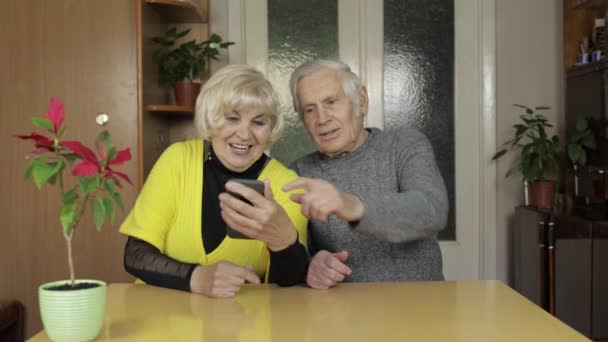 Довольно зрелая пожилая пара бабушка и дедушка делают видео-звонок с телефона дома
 - Кадры, видео