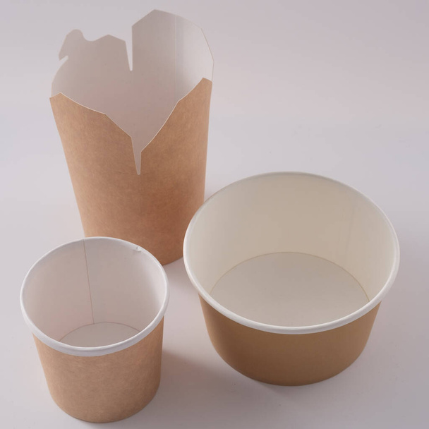 Street fast food paper cups, plates and containers. Eco-friendly food packaging on white background. Copy space. Carering of nature and recycling concept. - Fotografie, Obrázek