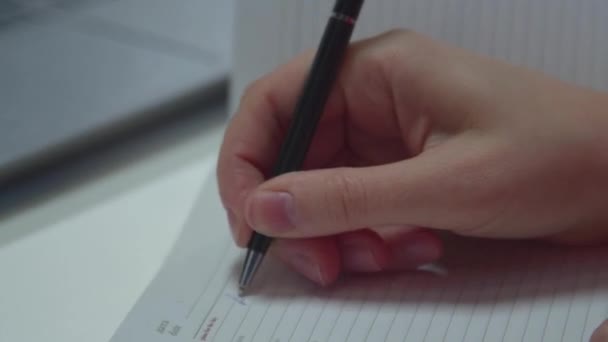 Księgowy pisze w notatniku i pracuje na laptopie - Materiał filmowy, wideo