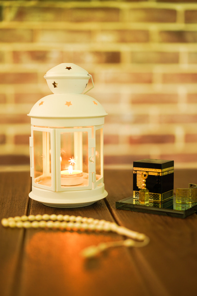 Conceito islâmico para Eid e Ramadhan. Lanterna árabe tradicional com miniatura Kaaba e Tasbih (contas de rosário) em um fundo de madeira
 - Foto, Imagem