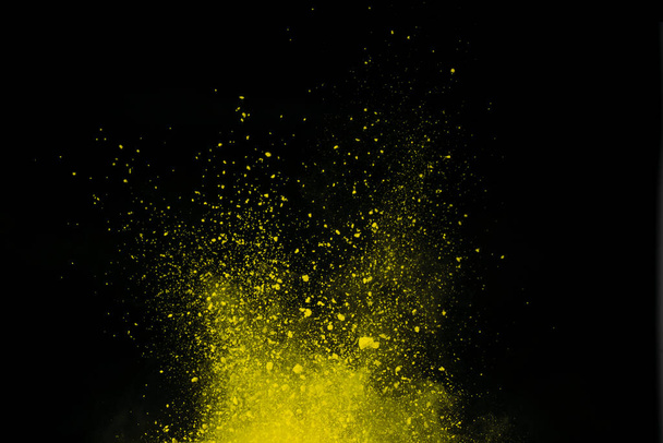Wybuch żółtego proszku na czarnym tle. Kolorowa chmura. Kolorowy pył eksploduje. Farba Holi. - Zdjęcie, obraz