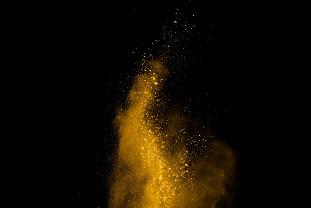 Έκρηξη κίτρινης σκόνης σε μαύρο φόντο. Χρωματιστό σύννεφο. Πολύχρωμη σκόνη εκραγεί. Βαφή Holi. - Φωτογραφία, εικόνα