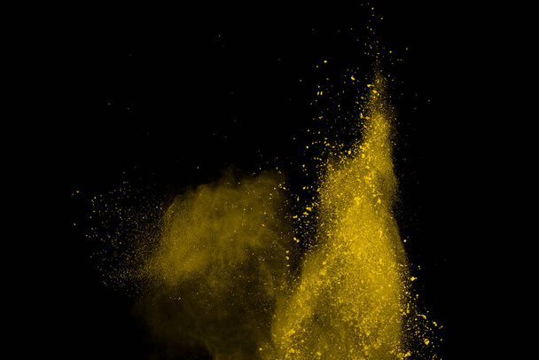 Wybuch żółtego proszku na czarnym tle. Kolorowa chmura. Kolorowy pył eksploduje. Farba Holi. - Zdjęcie, obraz