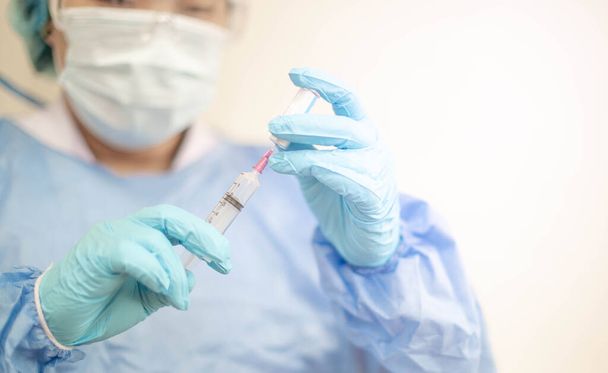 Медицинская инъекция шприца в руке с помощью оборудования для вакцинации лекарственных доз иглой. вакцинация пациента для защиты от коронавируса (COVID-19). Пандемия коронавируса в мире кризиса
.  - Фото, изображение