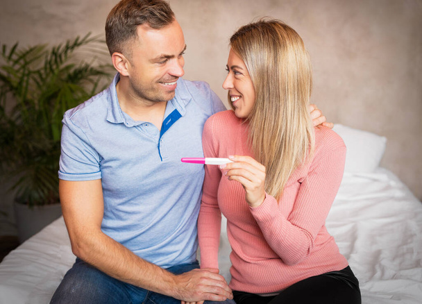 Ευτυχές ζευγάρι κοιτάζοντας θετικά τεστ εγκυμοσύνης - Φωτογραφία, εικόνα