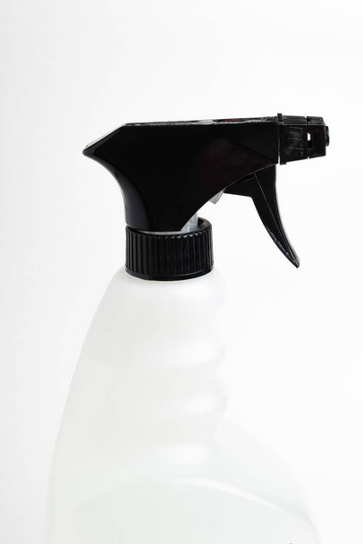  Un primer plano de la parte superior de una botella de dispensador de plástico en spray líquido blanco y negro sobre un fondo blanco liso
. - Foto, imagen