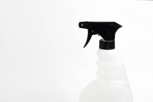  Eine Nahaufnahme des oberen Teils einer schwarz-weißen Sprühflasche aus Kunststoff auf einem schlichten weißen Hintergrund. - Foto, Bild