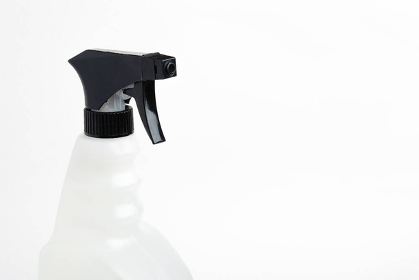  Een close-up van het bovenste gedeelte van een zwart-wit vloeistofspuit plastic dispenserfles op een effen witte achtergrond. - Foto, afbeelding
