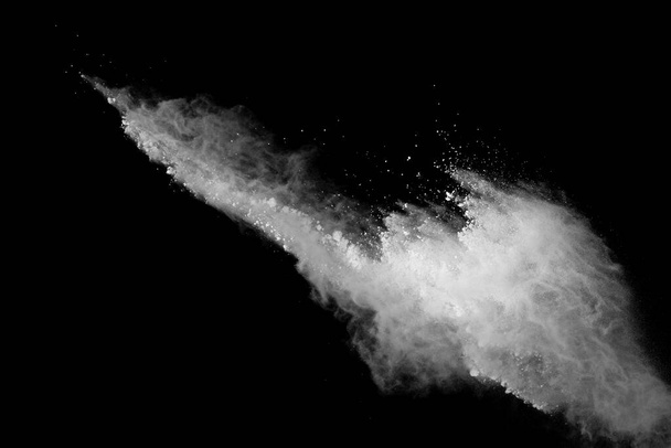 Freeze motion of white color powder exploding on black background. - Photo, Image