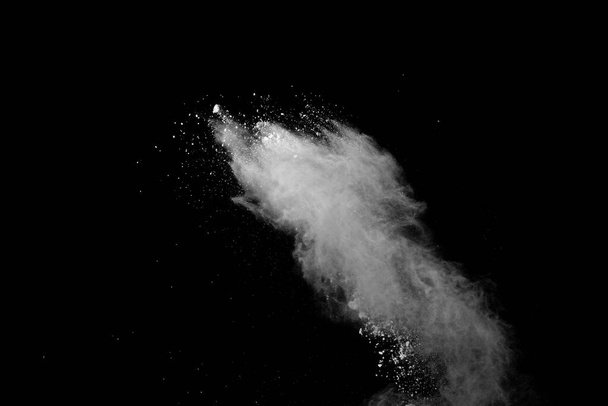 Παγωμένη κίνηση της σκόνης λευκού χρώματος που εκρήγνυται σε μαύρο φόντο. - Φωτογραφία, εικόνα