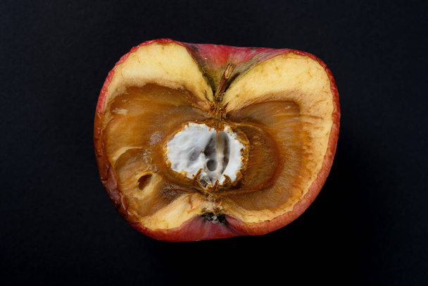 huonosti kutistunut omena homeinen ydin mustalla pohjalla
 - Valokuva, kuva