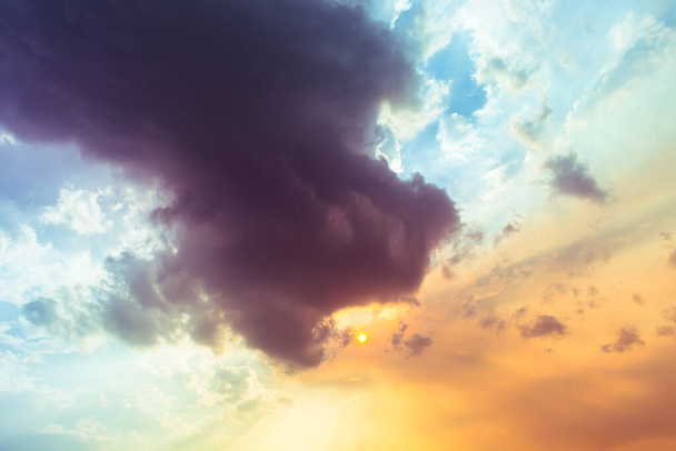 Oscuro púrpura Diablo Nubes están tragando el sol naranja, en el cielo de la noche
 - Foto, Imagen