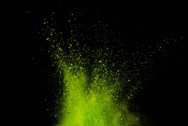 Взрыв зеленого порошка изолирован на черном фоне. Абстрактный цветной фон
. - Фото, изображение