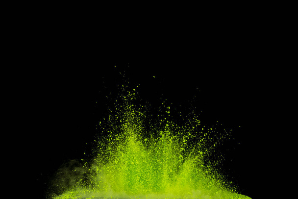 Взрыв зеленого порошка изолирован на черном фоне. Абстрактный цветной фон
. - Фото, изображение