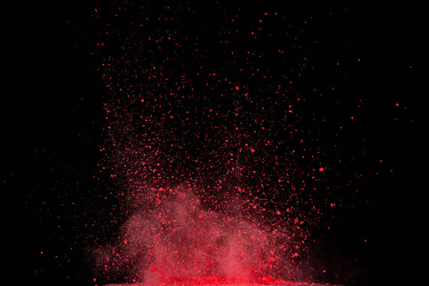 Red powder explosion on black background. - 写真・画像
