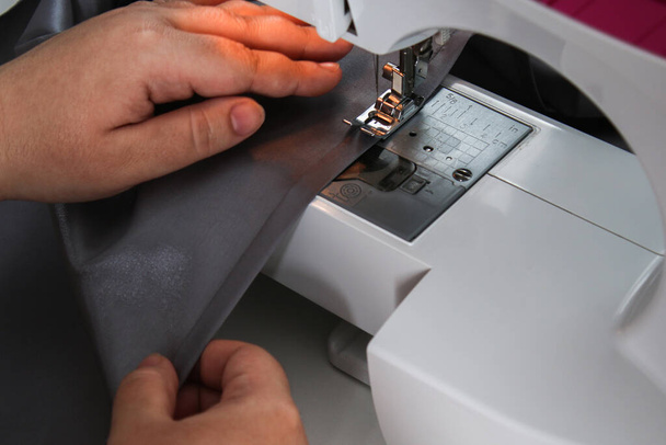 A man hem a curtain on sewing machine. Sewing, hobbies, hobby, home improvement. - Valokuva, kuva