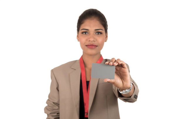 Smiling business woman holding a blank business card or ID card over white background - Fotoğraf, Görsel