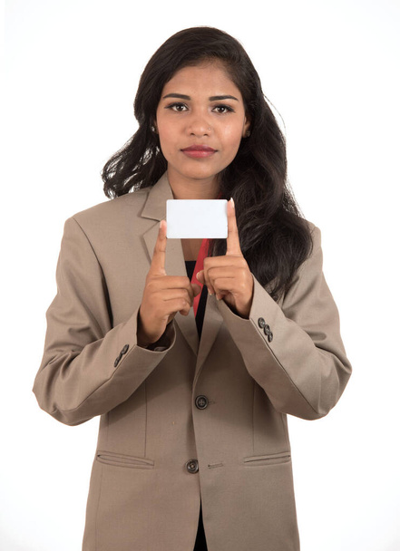 Smiling business woman holding a blank business card or ID card over white background - Fotó, kép