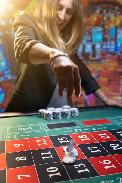 Woman playing roulette at the casino - Shallow depth of field - Фото, изображение
