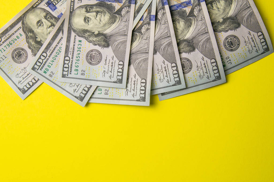 Száz dolláros bankjegyek színes háttér felülnézet, üres hely a szöveges üzleti pénz koncepció, amerikai dollár készpénz sárga háttér. - Fotó, kép