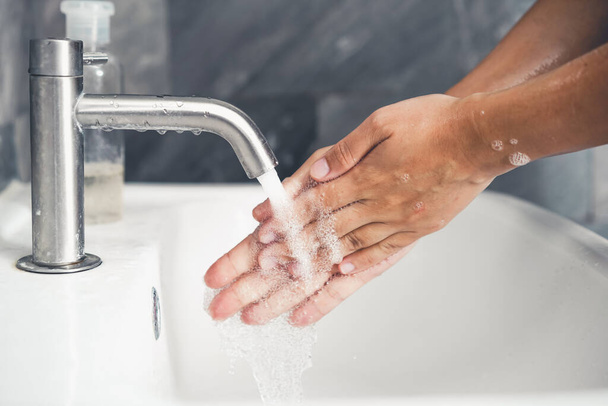 Hands washing for prevention of novel Coronavirus Disease 2019 or COVID-19 . People wash hands at bathroom sink to clean the virus infection. - Zdjęcie, obraz