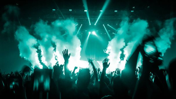 Счастливые люди танцуют в ночном клубе DJ party концерт и слушают электронную танцевальную музыку от DJ на сцене. Силуэт веселая толпа празднует Новый год 2020. DJ nightlife
. - Фото, изображение