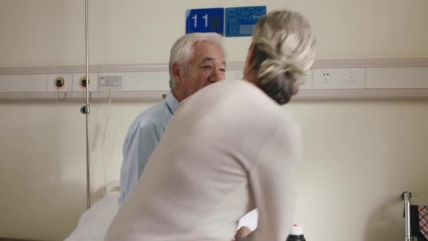 starszy Azji kobieta odwiedzając mąż w szpital oddział - Materiał filmowy, wideo