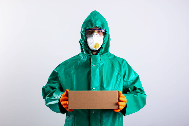 Person in whole-body garment bringing parcel during the pandemic - Foto, imagen