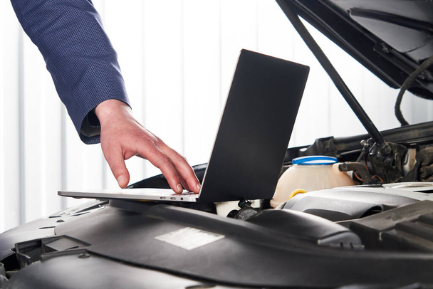 Car mechanic using computer in auto repair shop - Photo, Image
