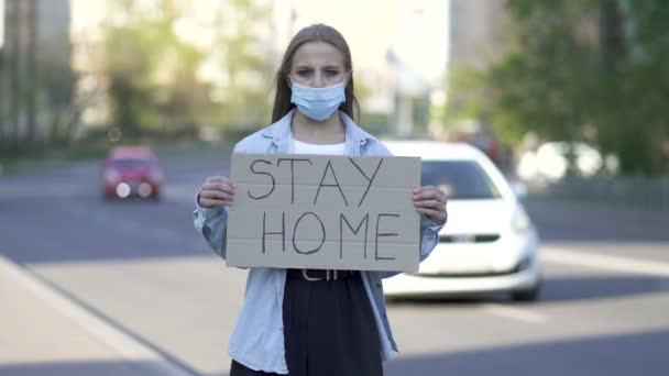 Woman in medical mask protest with poster on city street. Word pandemic team - Footage, Video