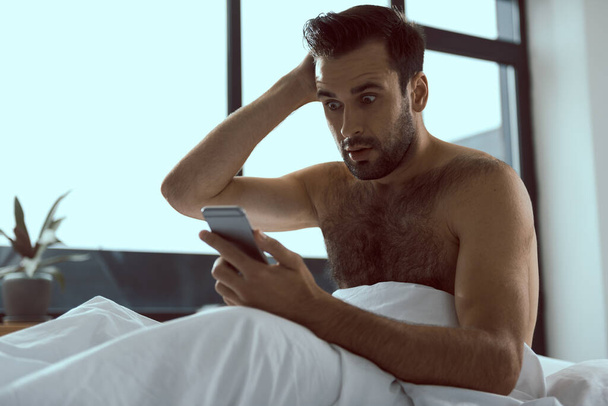 Young man with phone overslept and missed call - Fotoğraf, Görsel