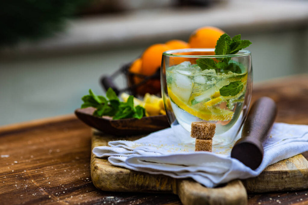 Delicioso cóctel de gin tonic con rodajas de limón y menta fresca sobre fondo rústico con espacio para copiar
 - Foto, imagen
