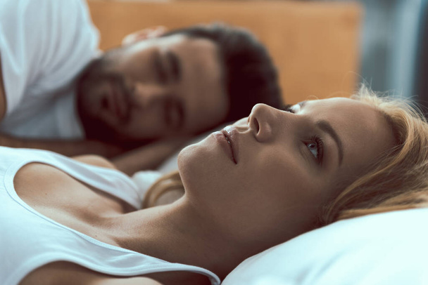 Tranquil female awaken near beloved man in bed - Foto, Imagem
